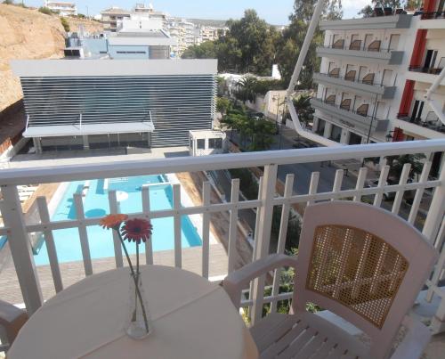 a balcony with a table and chairs and a pool at Hotel Bretagne in Loutraki