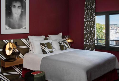 a bedroom with a large bed and a window at Hôtel Louvre Piemont in Paris