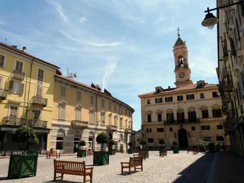 a group of buildings with benches and a clock tower at ITALIAN TOURiSM in Borgofranco dʼIvrea