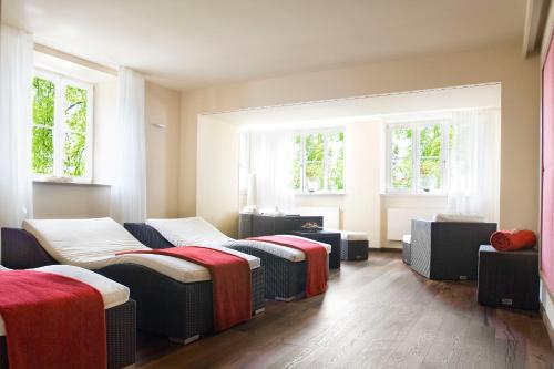 a room with three beds and two windows at Hotel Bad Schachen in Lindau