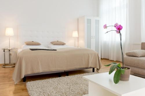 a white bedroom with a bed and a couch at Burgblickhotel in Bernkastel-Kues