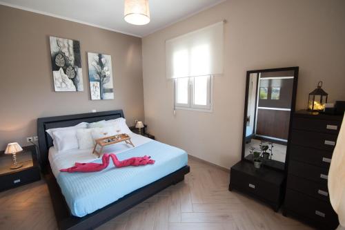 a bedroom with a bed with two red shoes on it at Villa Amfimala in Georgioupolis