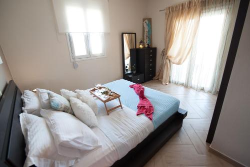 a pink dog sitting on a bed in a bedroom at Villa Amfimala in Georgioupolis