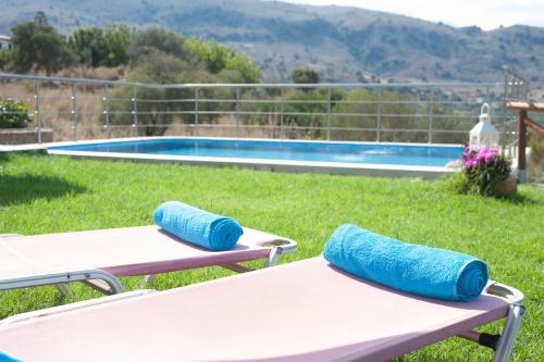 two lounge chairs in front of a swimming pool at Villa Amfimala in Georgioupolis