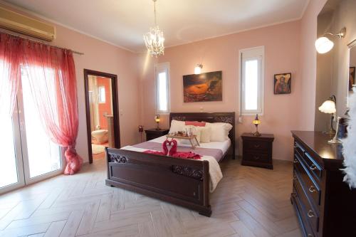 a bedroom with a bed and a dresser and windows at Villa Amfimala in Georgioupolis