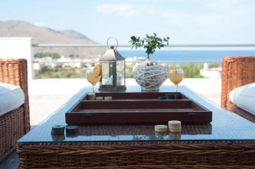 a coffee table on a patio with a view of the ocean at Villa Amfimala in Georgioupolis