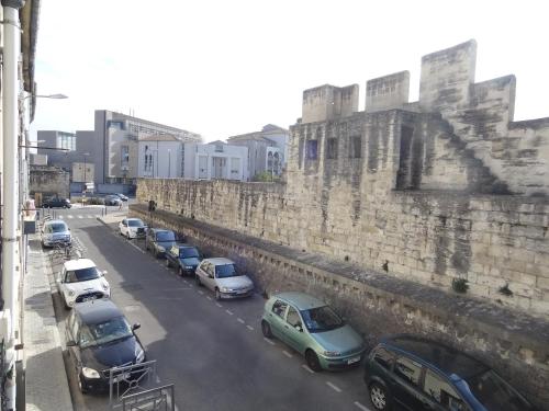 a row of cars parked next to a wall at Appartement HEMINGWAY in Avignon
