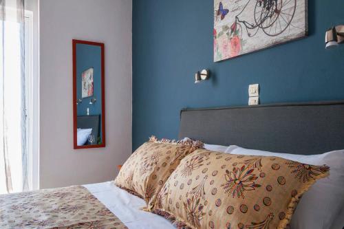 Schlafzimmer mit blauen Wänden und einem Bett mit Kissen in der Unterkunft Nikos Apartments in Agia Marina