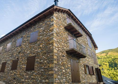 a stone building with a cross on top of it at Ca' la Júlia Vall de Boi in Barruera