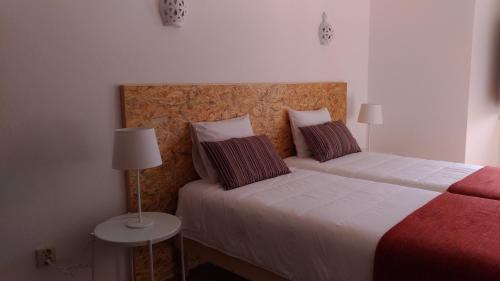 a bedroom with two beds and a table with a lamp at Route 2 Torrão in Torrão