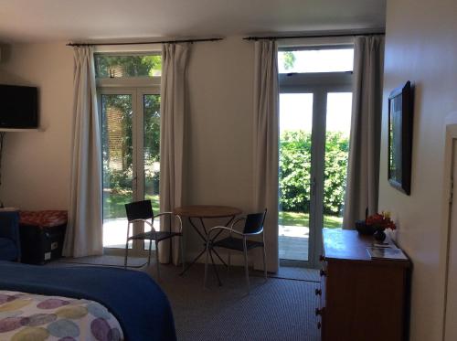 een hotelkamer met een bed en een tafel en stoelen bij Korohi Vineyard BnB in Blenheim