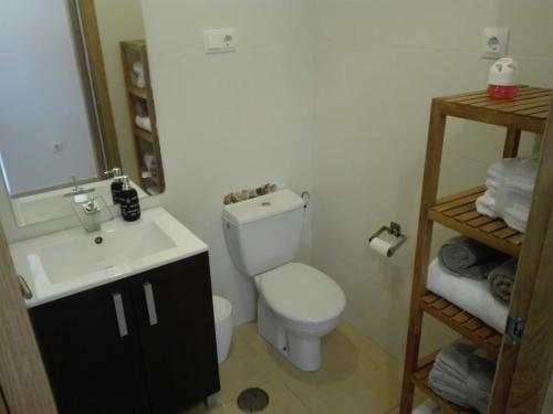 a bathroom with a white toilet and a sink at Aya in Murcia