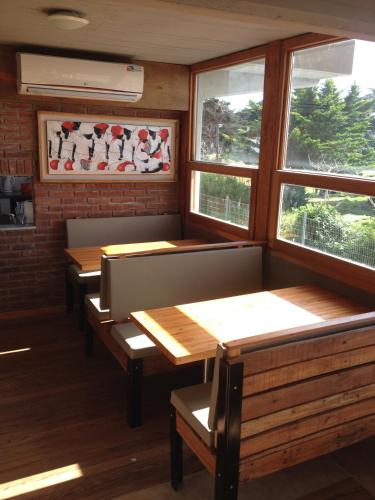a row of benches in a restaurant with windows at Complejo Sakura in Villa Gesell