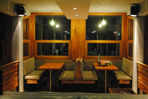 a restaurant with two tables and chairs and windows at Complejo Sakura in Villa Gesell