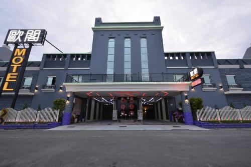 a blue building with a sign in front of it at OUGE Boutique Motel - Pingtung in Jiuru