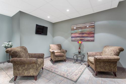 a waiting room with two chairs and a tv at Ramada by Wyndham Williams Lake in Williams Lake