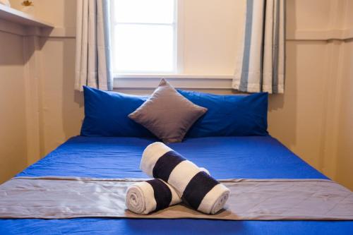 a bed with a pair of socks on it at Mad Monkey Central in Cairns