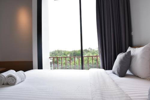 a bedroom with a bed with a large window at B Boutique Residence in Suratthani