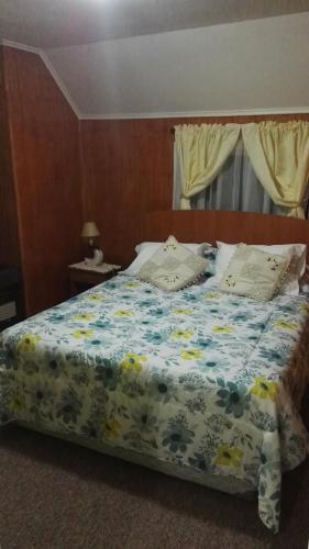 プエルトモントにあるCasa-Departamento Gimar Choroyのベッドルーム1室(花柄の掛け布団付きのベッド1台付)