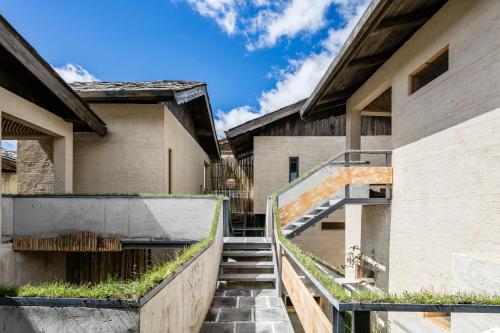 eine Treppe, die zu einem Gebäude mit Gras führt in der Unterkunft Shangri-La Karesansui Hotel in Shangri-La