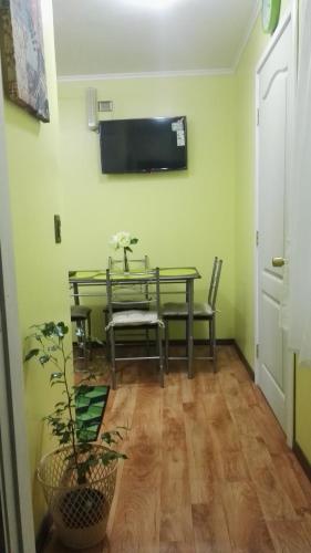 comedor con mesa y TV en la pared en Casa-Departamento Gimar Choroy, en Puerto Montt