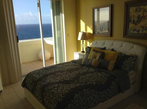 a bedroom with a bed with a view of the ocean at Great Ocean Views! in Tamuning
