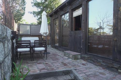 a patio with an umbrella and a table and chairs at Las Horas Perdidas in Manzanares el Real