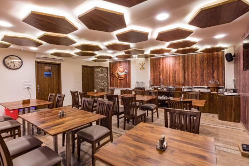 a dining room with wooden tables and chairs at Hotel City Inn in Gandhinagar