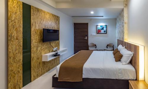 a hotel room with a bed and a tv at Hotel City Inn in Gandhinagar