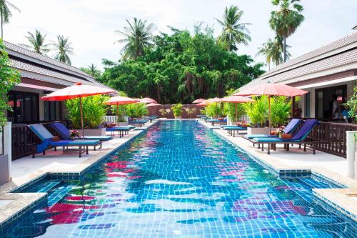 a swimming pool with chairs and umbrellas at a resort at The Florist Resort in Mae Nam