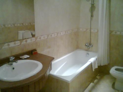 a white bath tub sitting next to a white sink at Desert View Sharm Hotel in Sharm El Sheikh