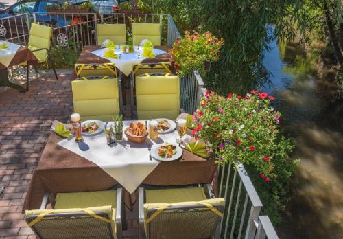 a table with plates of food sitting on a patio at Hotel Restaurant Lohmühle in Bayreuth