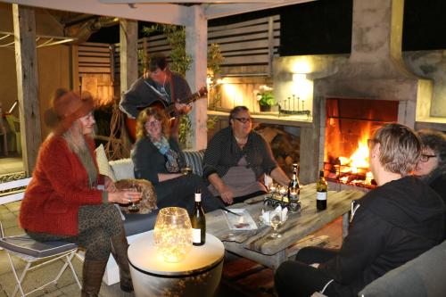 a group of people sitting in a room with a fireplace at La Riviera Guesthouse in Riverton