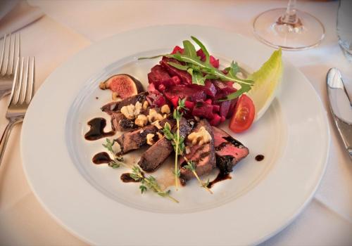 a white plate of food on a table at Hotel Restaurant Lohmühle in Bayreuth