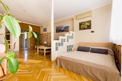 a bedroom with a bed and a wooden floor at East Station Studios - Baross Home 1 & 2 in Budapest