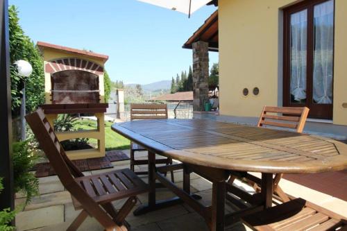 グレーヴェ・イン・キアンティにあるVilla Dei Sogniの木製テーブルと椅子付きのパティオ