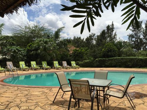 a table and chairs next to a swimming pool at Arusha Planet Lodge in Arusha