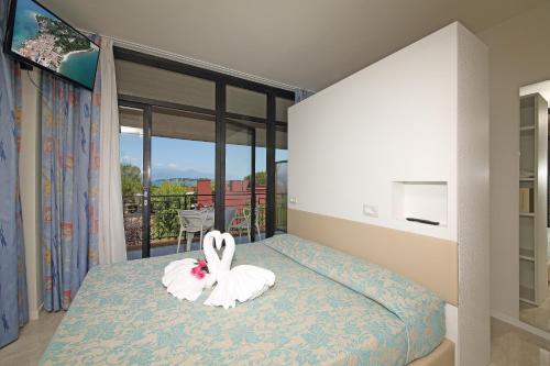 a bedroom with a bed with a bunny on it at Hotel Holiday in Sirmione