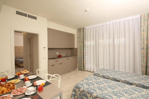 a room with a bed and a table with food on it at Hotel Holiday in Sirmione