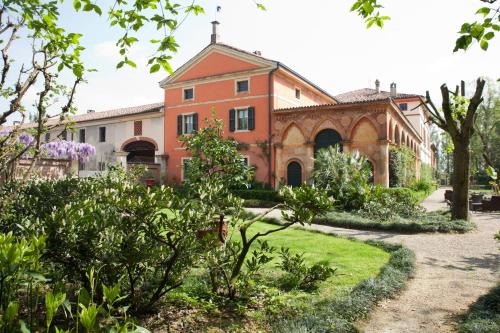 an old building with a garden in front of it at Agriturismo Cascina Farisengo in Stagno Lombardo