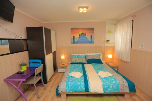 a bedroom with a bed and a desk and a television at Apartment Centar in Pula