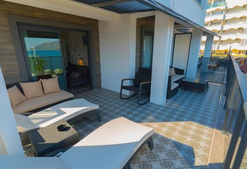 a patio with a couch and chairs on a balcony at Marmaris Beach Hotel in Marmaris