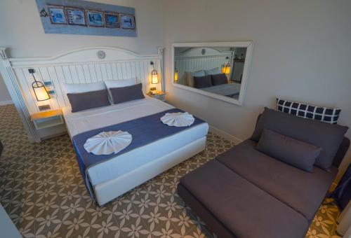 a bedroom with a bed and a mirror and a couch at Marmaris Beach Hotel in Marmaris