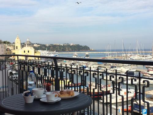 a table with two cups of coffee on a balcony with a harbor at L'Isola Del Postino Rooms in Procida