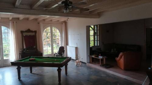 un salon avec une table de billard dans l'établissement B&B Les Quatre Vents, à Montpon-Ménestérol