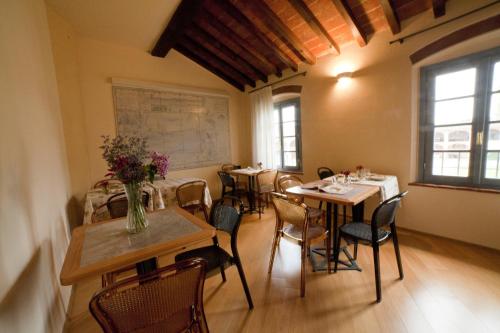 Agriturismo Cascina Farisengo في Stagno Lombardo: غرفة بها طاولات وكراسي وخريطة على الحائط