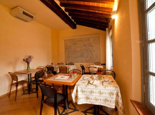 a dining room with tables and chairs and a window at Agriturismo Cascina Farisengo in Stagno Lombardo