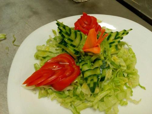 een bord groenten met tomaten en broccoli bij Familly Art Hotel Nirvana in Shumen