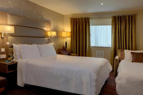 a hotel room with two beds and a window at Best Western Pontypool Metro Hotel in Pontypool