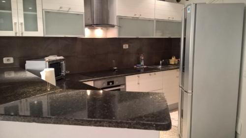 a kitchen with a black counter top and a refrigerator at Appartement Ain Zaghouan in Tunis